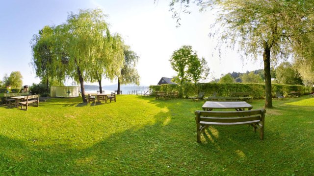 Am eigenen Badestrand - die große Liegewiese - Ferienwohnungen & Bungalows am Faakersee