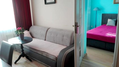 Apartament-wejscie do sypialni z dużego pokoju.